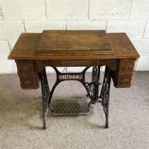 A vintage Singer sewing machine and table, with iron supports and treadle, 77cm high, 93cm wide