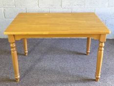 A varnished pine kitchen table, with rectangular top and set on four turned legs, 78cm high, 140cm