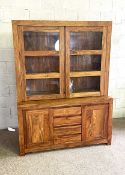 A contemporary hardwood, possibly teak, display cabinet, with two glazed cabinet doors over a base
