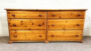 A modern pine double width chest of six drawers, with serpentine top, 168cm wide; also a matching