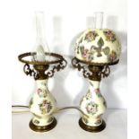 A pair of Victorian style decorative oil lamps, each with a baluster base, decorated with panels