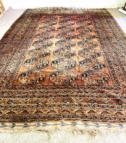 A large Tekke Turkmen carpet, 20th century, with three rows of guls on a madder field, within