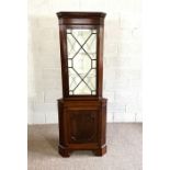 A George III style floor standing corner cabinet, with a glazed display case over a panelled cabinet