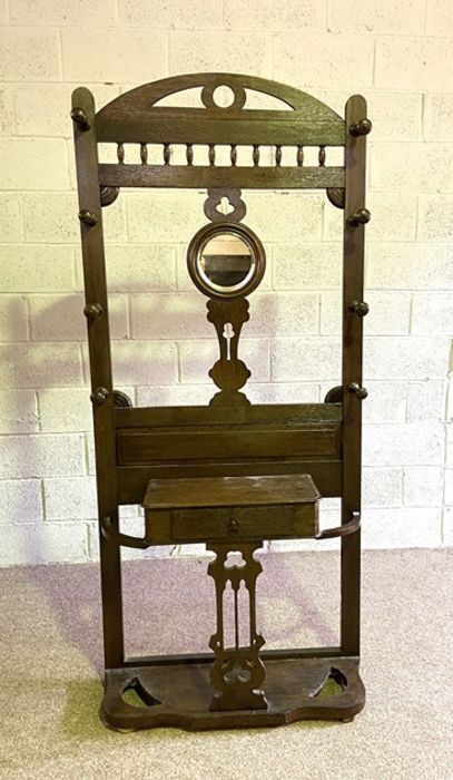 A late Victorian oak hall stand, with arched top, hat hooks and compartments for sticks