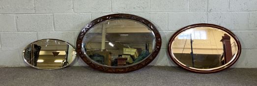 Three assorted oval wall mirrors, also a table top toilet mirror (4)