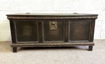 An oak 17th century style coffer, with hinged lid, three panelled front and iron strap hinges,