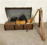 A trunk containing a large assortment of vintage camera equipment, including development, tripod,