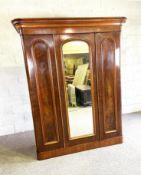 A mid Victorian mahogany wardrobe, circa 1870, with a moulded cornice over a central mirrored door
