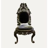 An Anglo Indian ebonized carved and upholstered easy chair, late 19th century, with inset back