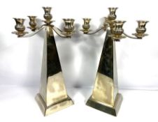 A pair of contemporary silver plated obelisk five light candelabra, each surmounted by two scroll