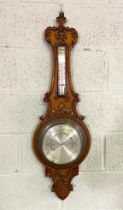 A late Victorian oak cased aneroid barometer and thermometer, with stiff leaf carved case, 96cm
