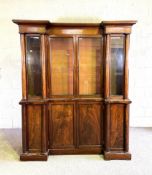 A George IV mahogany breakfront bookcase, with four glazed doors opening to adjustable shelves,