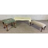 A small white painted coffee table; together with two upholstered tapestry foot stools (3)