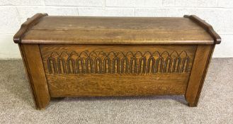 A handy vintage oak coffer, in 17th century style, with planked and cleated top and carved front,