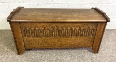 A handy vintage oak coffer, in 17th century style, with planked and cleated top and carved front,