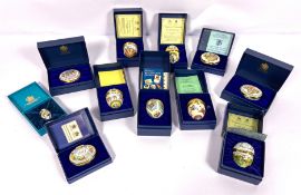 A large group of assorted Halcyon Days enamelled trinket boxes and Easter eggs, with original cases;