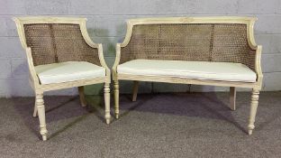 A Regency style painted and caned bergere canapé (settee) and matching armchair, each with a bowed