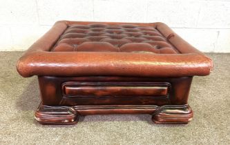 A small button upholstered 'leathered' footstool, including compartment base