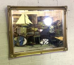 A modern gilt framed composition wall mirror, with scroll decorated corners and bevelled plate
