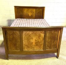 An Edwardian mahogany panelled double bedstead, with bowed end and decorative inlays.  Standard