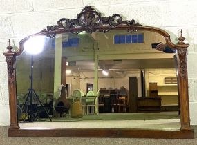 A large Victorian walnut framed overmantel mirror, circa 1870, with an arched top and carved