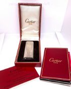 A Cartier silver plated vintage oval lighter, numbered 839955, with box, with service certificate