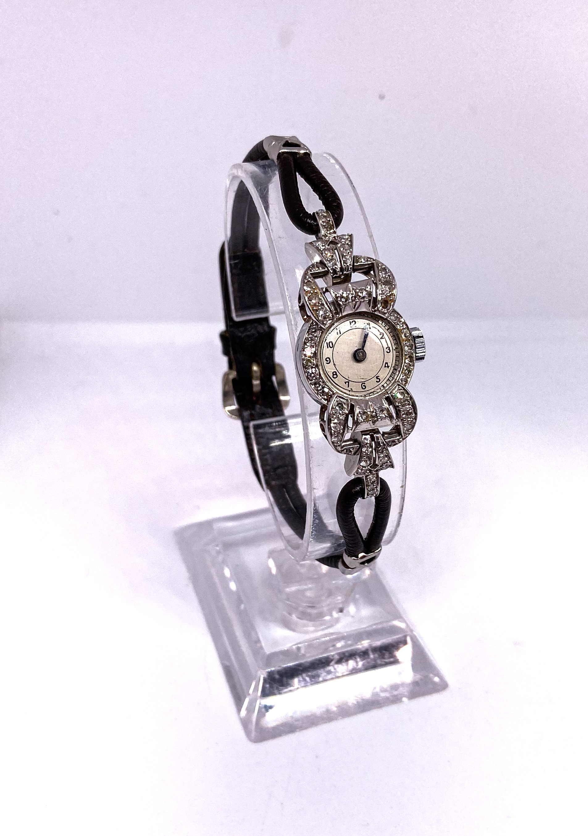A ladies vintage cocktail watch, with white metal case, and diamond chip decorated face (movement