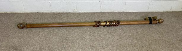 A vintage wooden curtain pole with wooden finials and 12 rings; 210cm x 6cm diameter