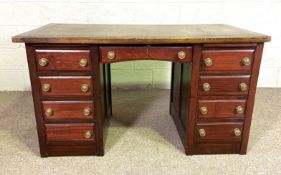 A vintage kneehole desk, with arrangement of nine drawers and leathered top