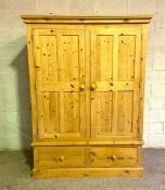 A good and large pine double wardrobe, with moulded cornice, over two panelled doors, opening to