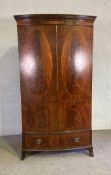 A George III style reproduction mahogany bowfronted double wardrobe, with oval veneered doors,
