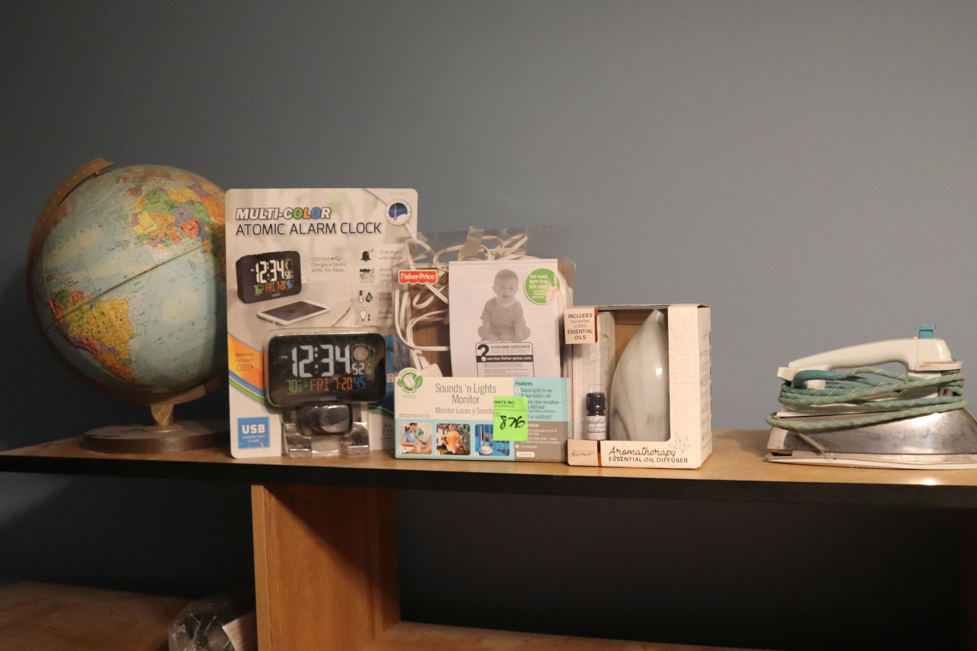 Group including everything on top of entertainment center, globe, alarm clock, baby monitor, essenti