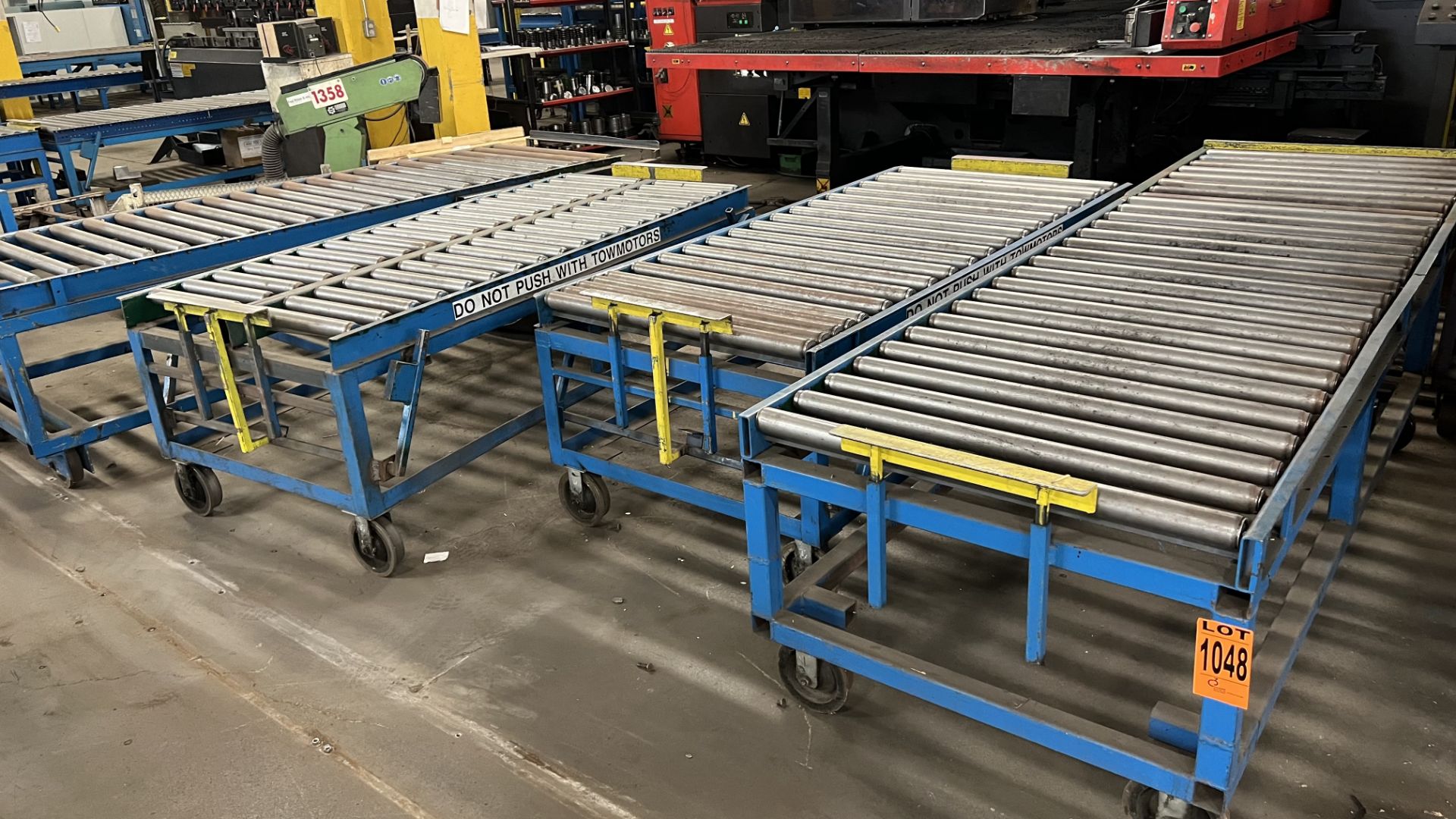 Lot of (4) sections of steel frame manual roller conveyors each w/ w-rail wheels and 2 casters, w/ a