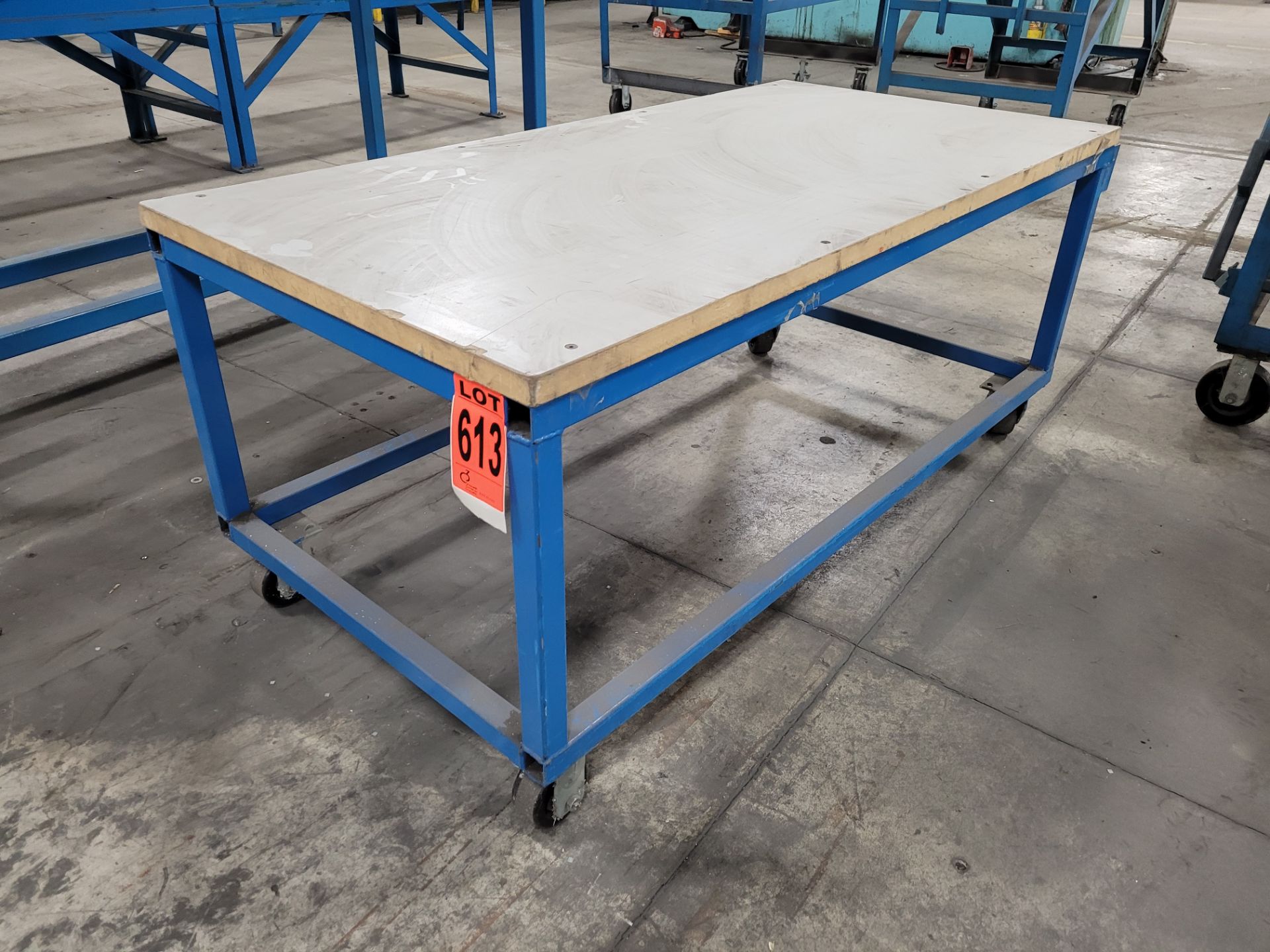 Mobile steel frame worktable on casters w/plywood surface