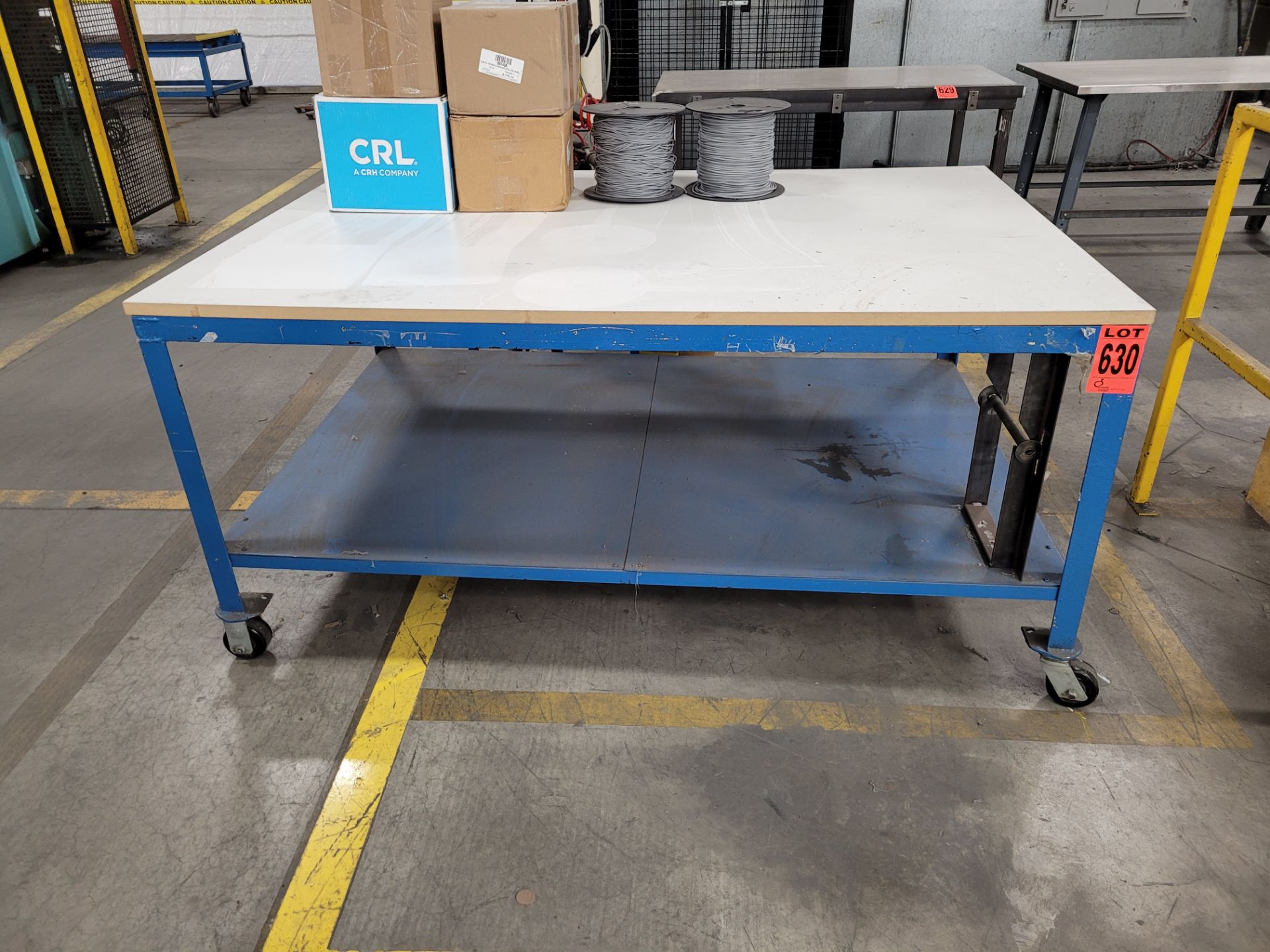 Mobile steel frame worktable on lockable casters w/plywood surface (no contents)