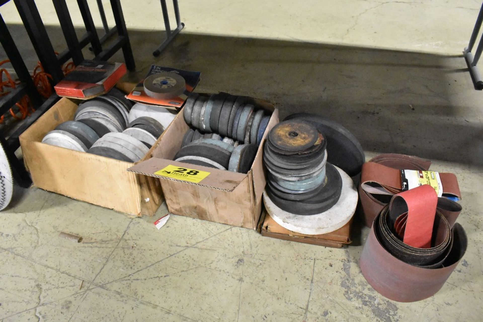 ASSORTED GRINDING WHEELS AND ABRASIVE BELTS UNDER BENCH