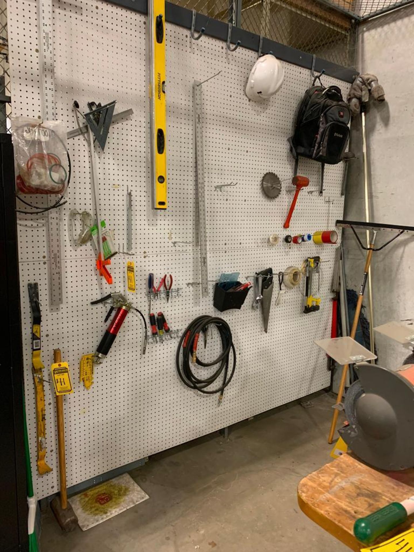 Tools Hanging on Pegboard, Bolt Cutters, Measuring Wheel, Extension Cords Hanging on Outside of Cage