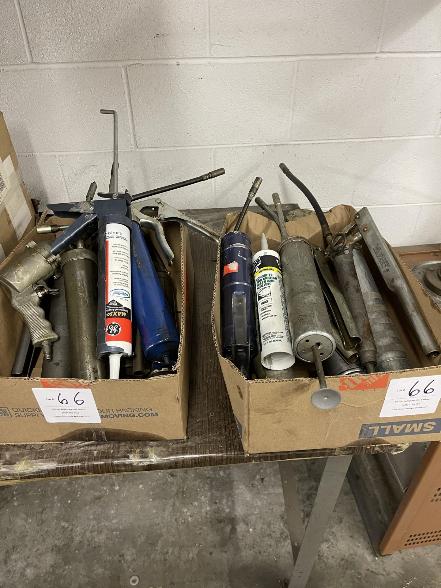 Two boxes of grease guns and caulking guns