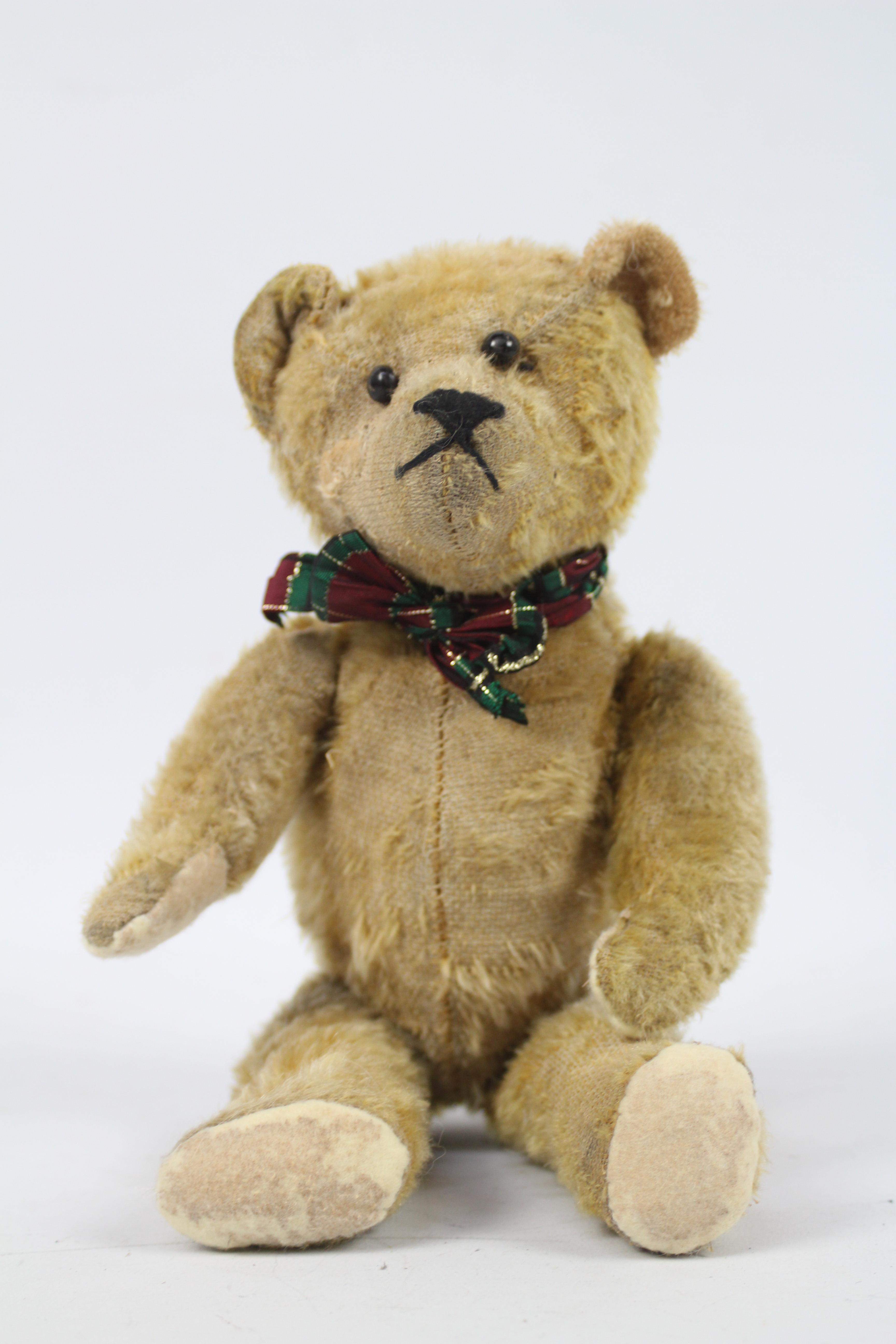A sawdust filled mohair teddy bear - measuring approx 33 cms in length, having jointed limbs,