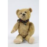 A sawdust filled mohair teddy bear - measuring approx 33 cms in length, having jointed limbs,