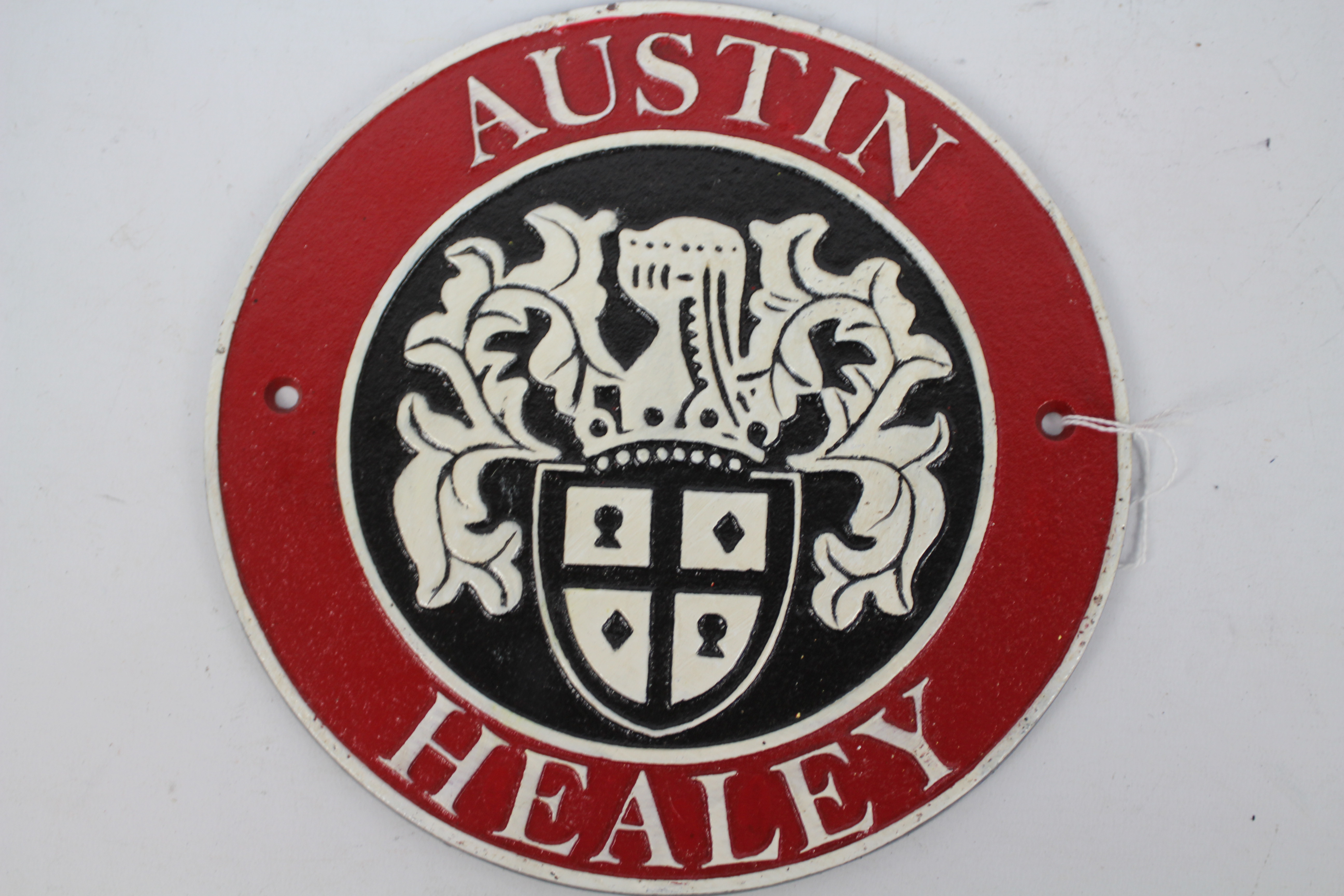 A cast iron wall plaque marked Austin Healey, approximately 24 cm (d).