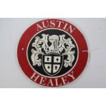 A cast iron wall plaque marked Austin Healey, approximately 24 cm (d).