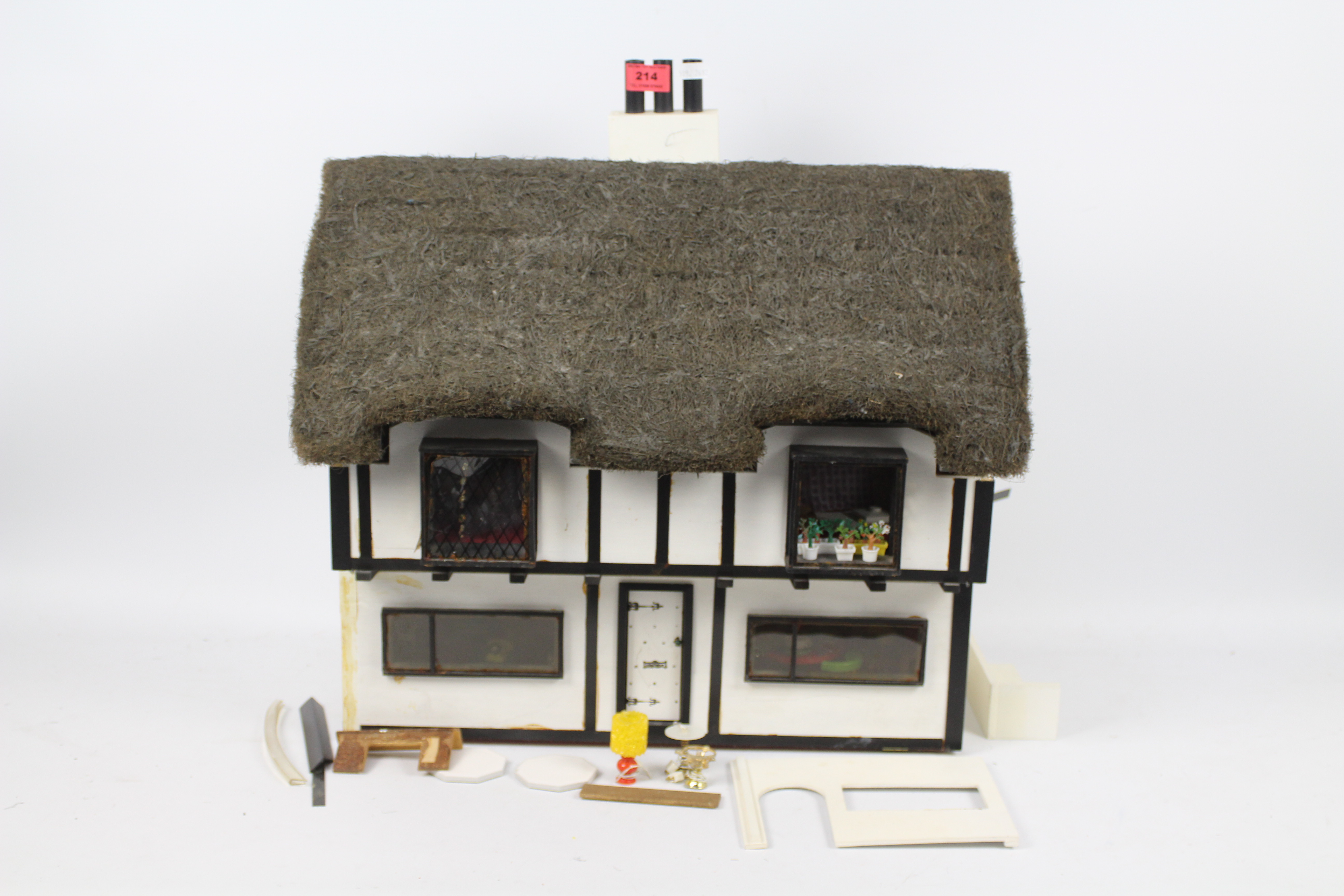 Dolls house - A home made, wooden, thatched, dolls house with electricity fittings for lights.