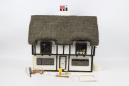 Dolls house - A home made, wooden, thatched, dolls house with electricity fittings for lights.