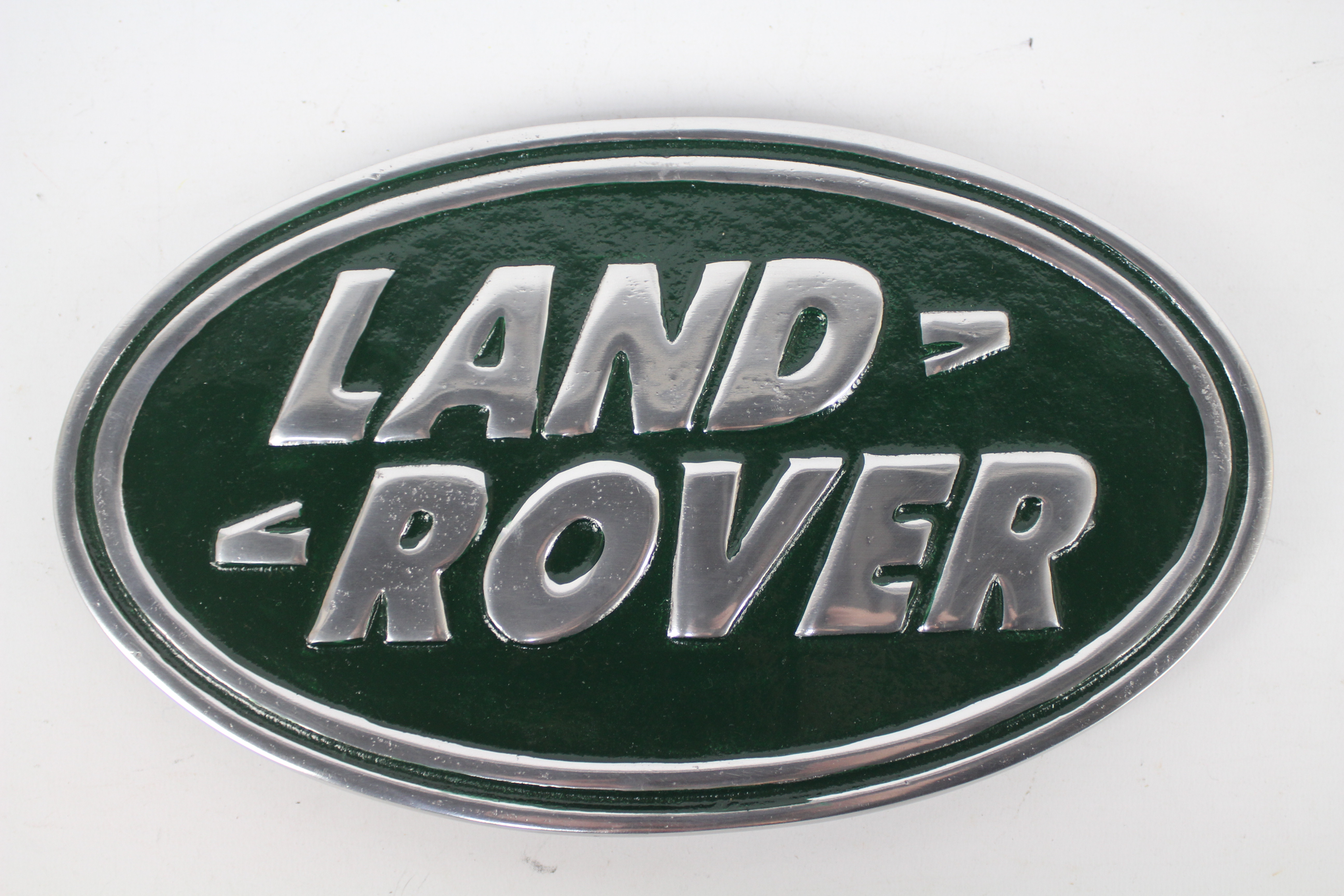 An oval shaped, aluminium plaque, marked Land Rover, approximately 18 cm x 30 cm.