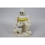 A cast iron figure depicting Bibendum (Michelin Man) with a dog, approximately 21 cm (h).