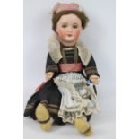 A vintage bisque head doll - The jointed doll measures approximately 44cms in height,