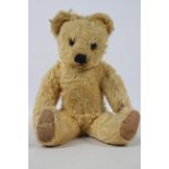 A Merrythought Teddy Bear, 1940s, with golden mohair body, orange and black glass eyes,