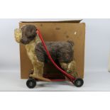 Tri ang - Pedigree Soft Toys - Push along Dog in red frame with black rubber wheels. Label in tact.