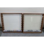 Two wall mounted glass fronted wooden display cabinets with glass shelves.